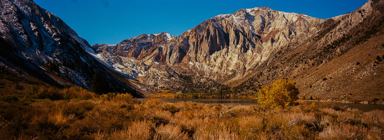 A mountain amphitheater above a lake and golden autumn scrub