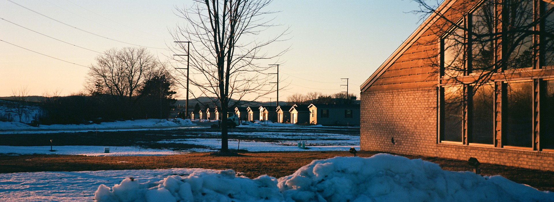 Low winter sunlight across a snowy roadside motel